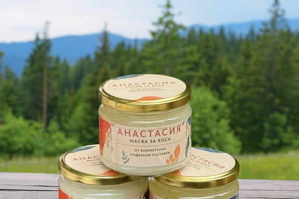 Три буркана маска за коса „Анастасия“ на дървена маса пред родопска гора