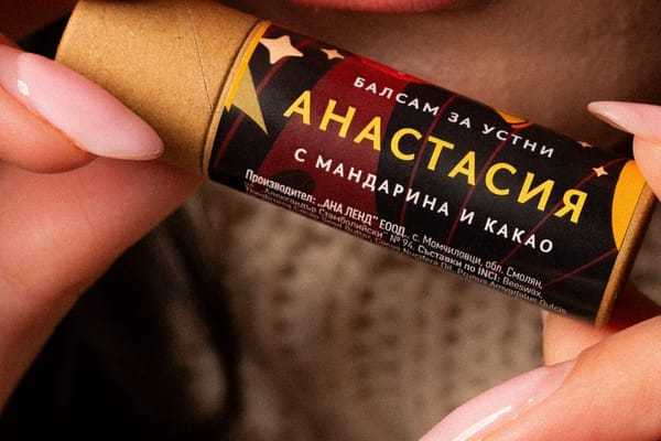 Жена държи отворен балсам за устни „Анастасия“ до устните си