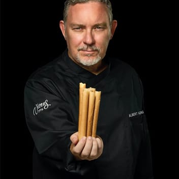 Albert Adrià в черно сако Torrons Vicens, с блокче турон в ръка