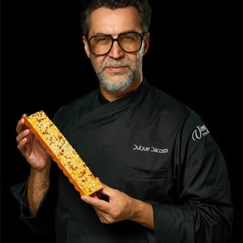 Quique Dacosta в черно сако Torrons Vicens, с блокче турон в ръка