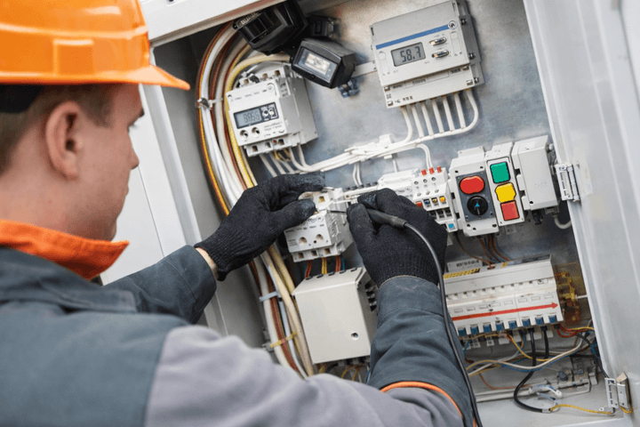 man with contruction cap measuring the electric value with tool