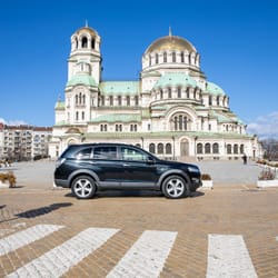 Black Chevrolet Captiva side view in front of church