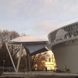 Страничен изглед на опънатата мембрана, хармонично интегрирана с фасадата на сградата, подчертаваща модерната естетика.