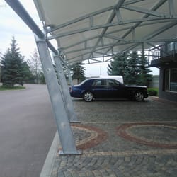 Longitudinal underside view of the textile canopy at Sanitex parking zone, featuring front support columns with decorative openings.