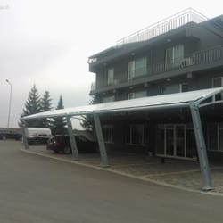 Diagonal side view of the textile canopy at Sanitex parking zone, captured from a distance.