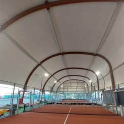 Εσωτερική άποψη της εφελκυόμενης μεμβράνης και της ασύμμετρα λοξής καμάρας που καλύπτει τα δύο γήπεδα πάντελ.