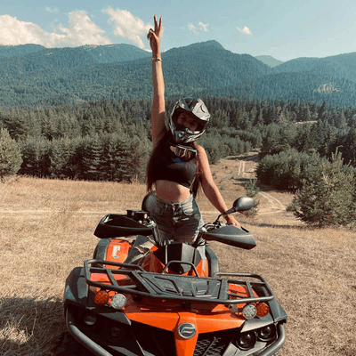 girl rising hand while riding atv